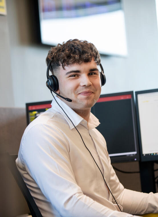 alt="male call centre operator wearing headset"