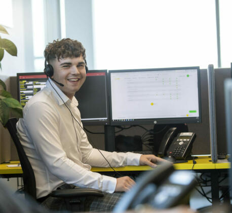 alt="male contact centre operator smiling at camera"