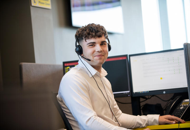 alt="male call centre operator wearing headset"